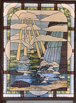 stained glass window of stream, trees, animals