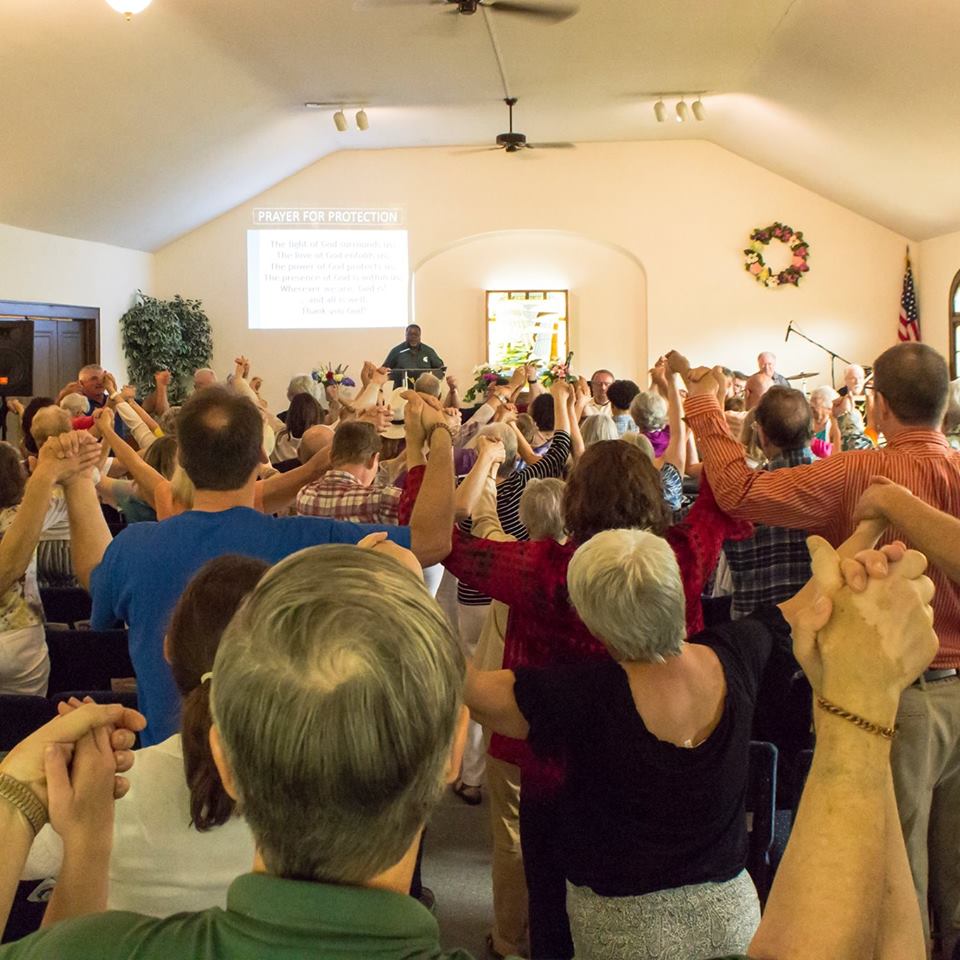 group of people holding hands above their heads