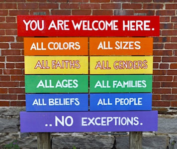 brick wall with rainbow colors and words of diversity